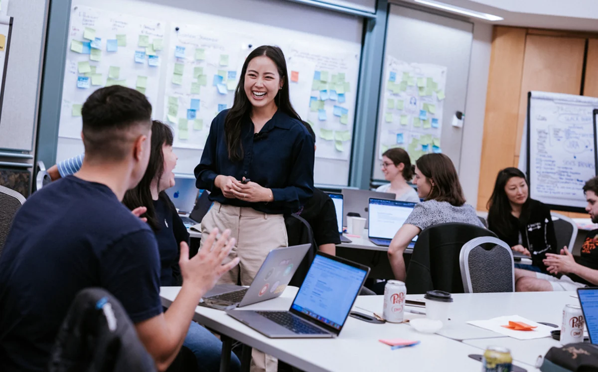 Lorraine K. Lee leading a workshop with a team around a table
